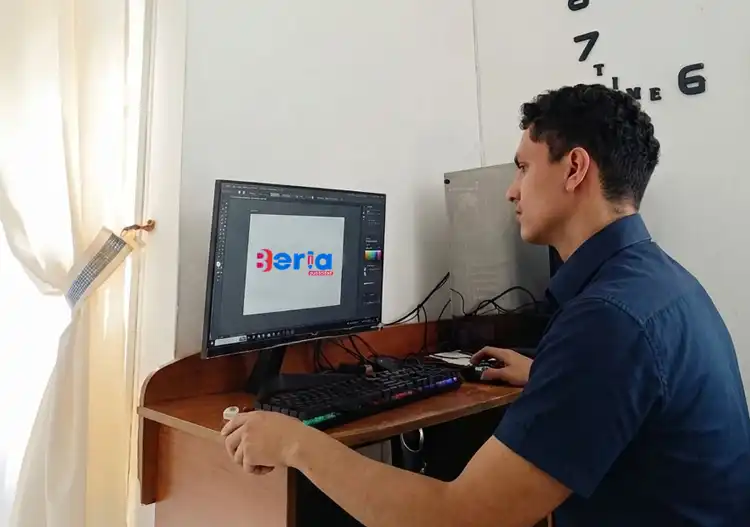 Escritorio moderno de diseño gráfico con laptop mostrando iconos de identidad visual y herramientas creativas, servicio de Beria Publicidad en Villavicencio.